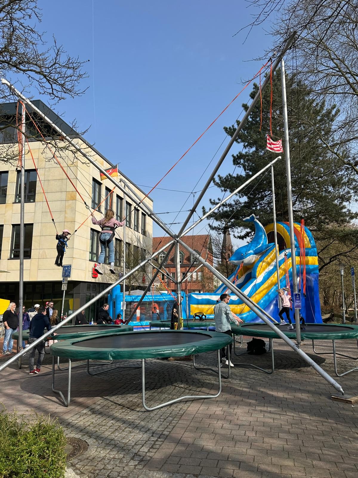 Kinder springen gesichert an der 4er-Bungee-Trampolinanlage von Galaxy Jump